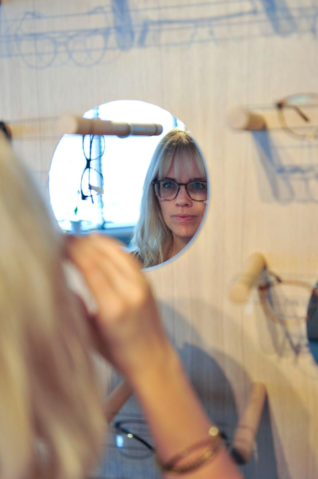 Bilde av dame som prøver briller hos Erøy Optikk i Rona, Kristiansand